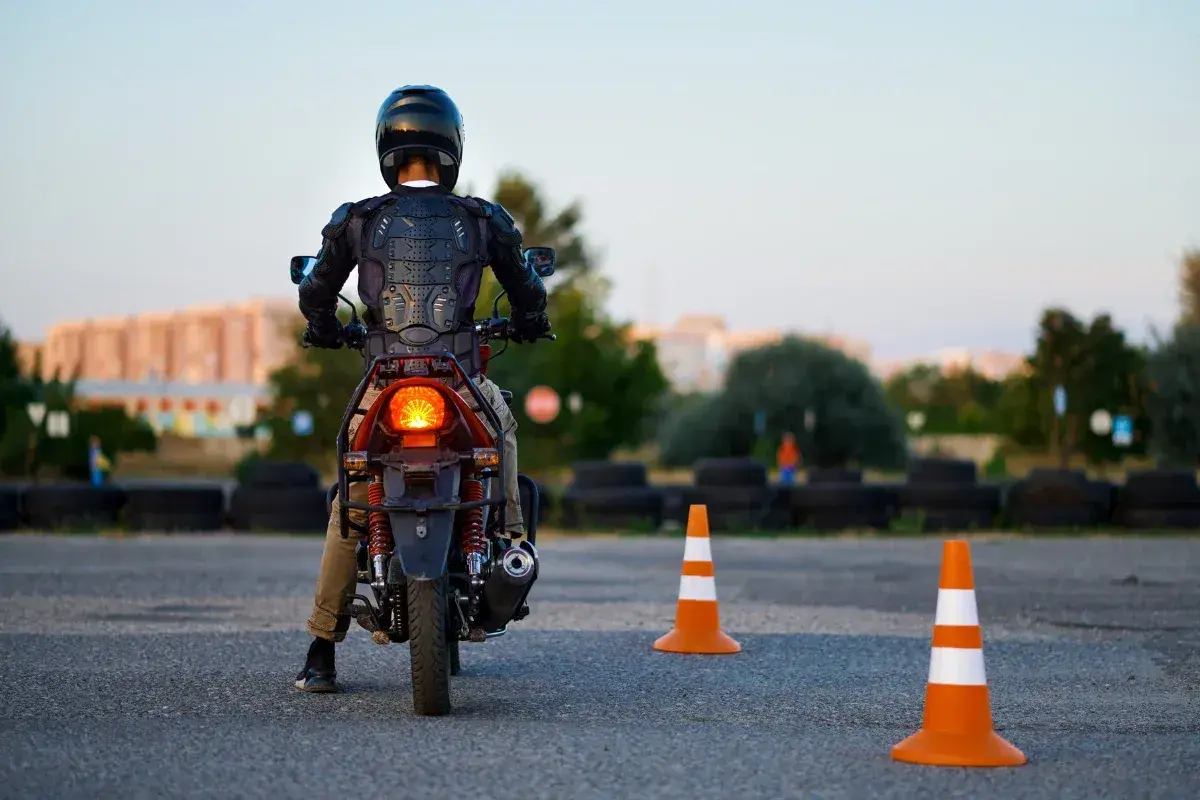 Motorcyklist i skyddsutrustning på en konbana, redo att öva.