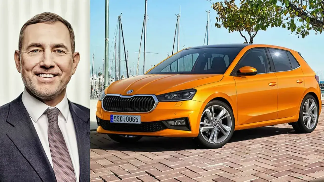 En leende man bredvid en orange Skoda Kamiq. Kanske är det en ny modell, eller så finns det ett Skoda Kamiq problem som diskuteras.