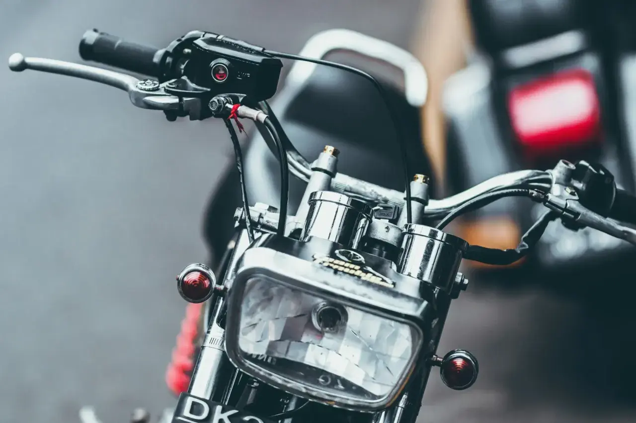 Detaljerad bild av en klassisk a1 motorcykel med kromade detaljer och en rektangulär strålkastare.