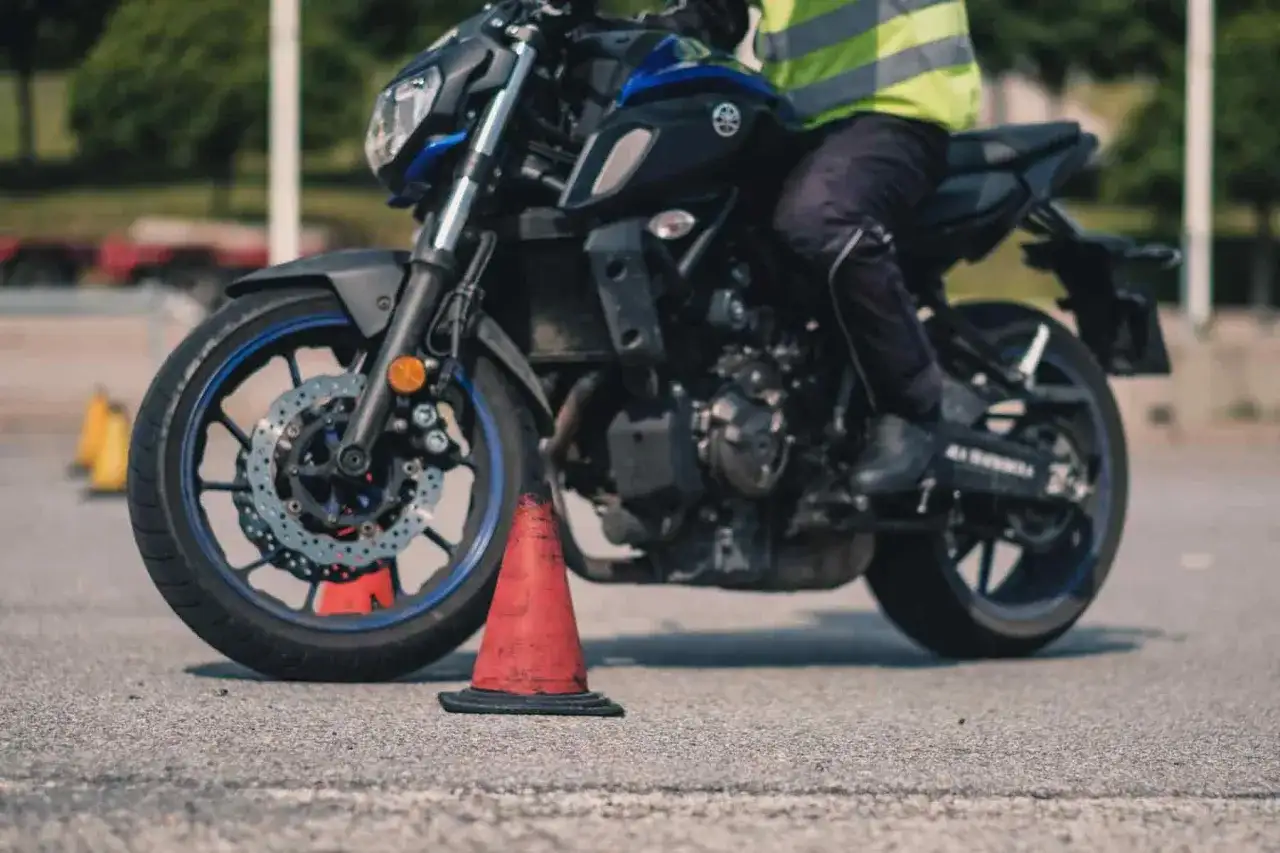 Person på motorcykel övar på mc kort med koner.