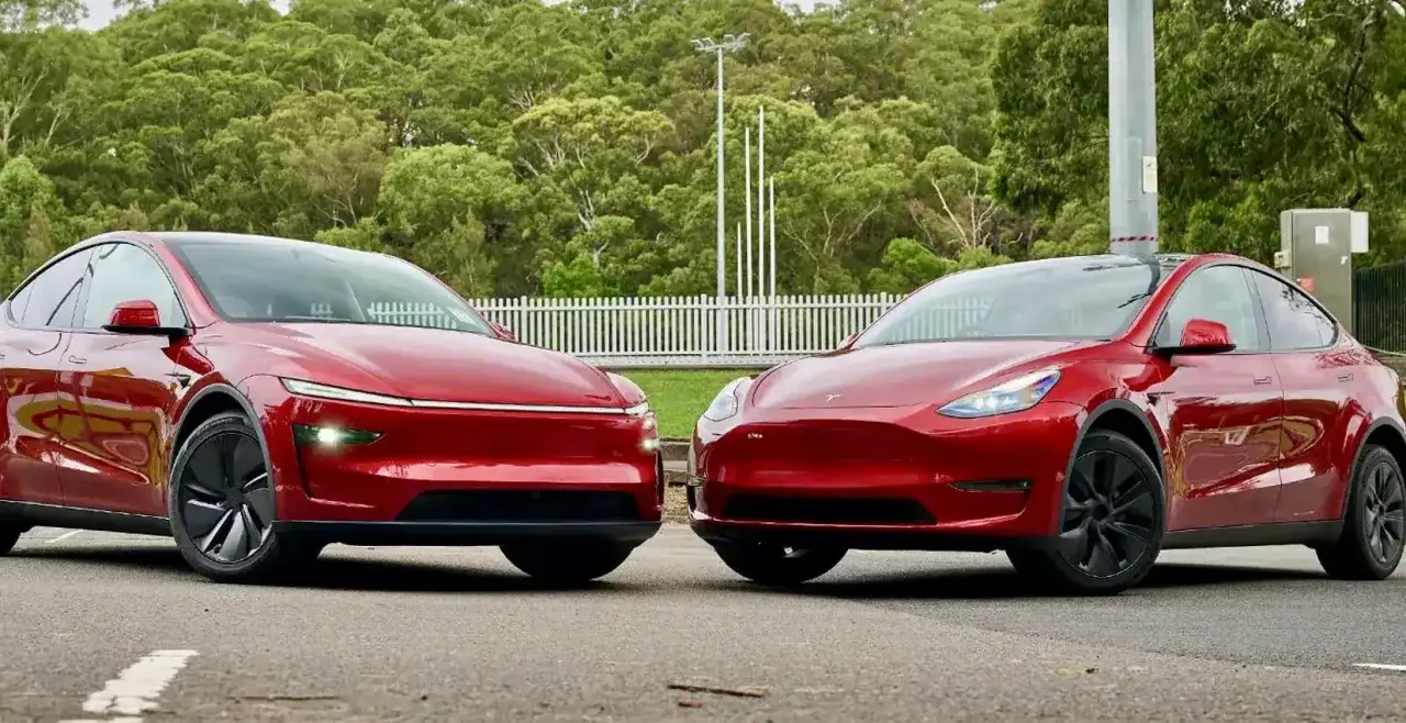 Två röda elbilar, en Tesla och en annan modell som påminner om en tesla juniper, står sida vid sida.