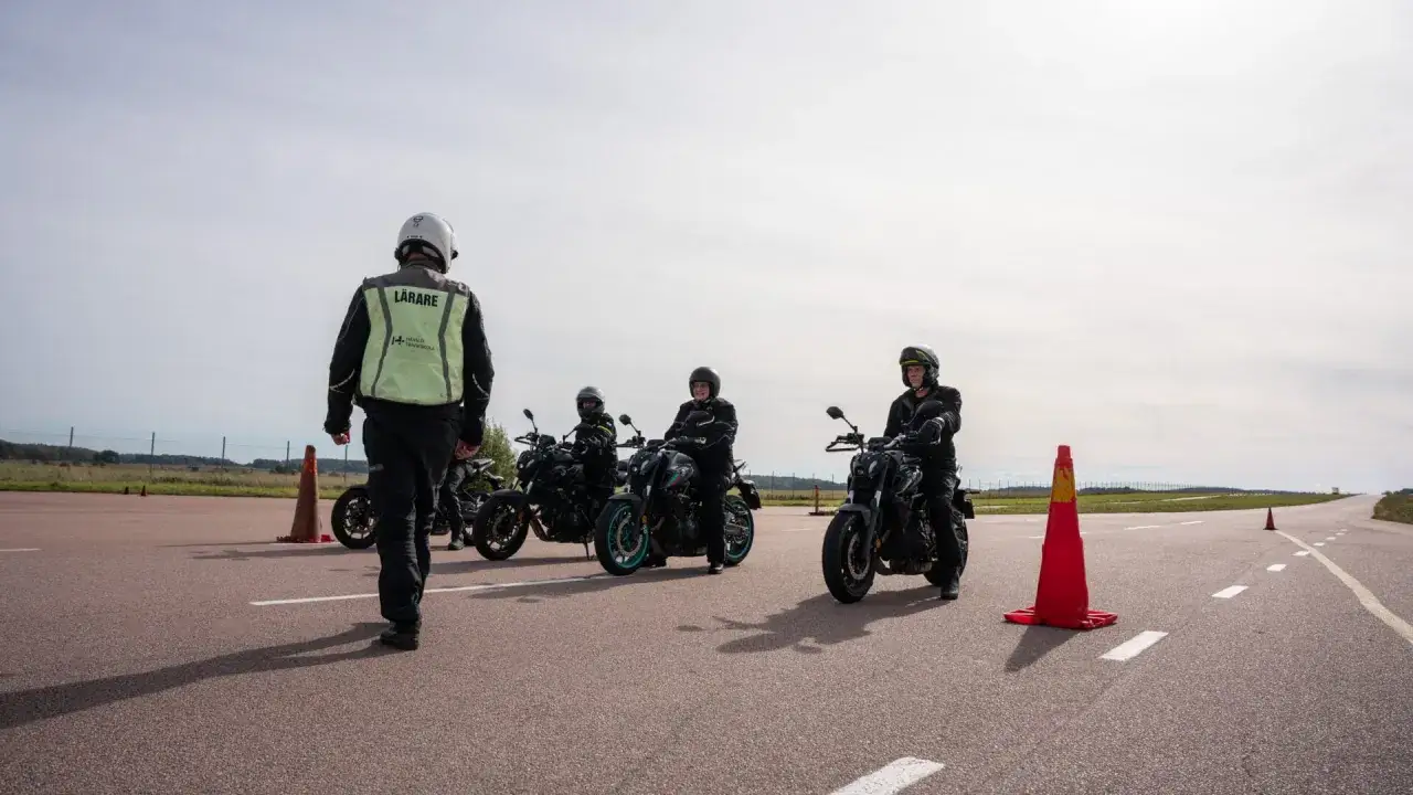 Instrukt&ouml;r leder elever p&aring; motorcyklar under en risktv&aring;an mc-utbildning.