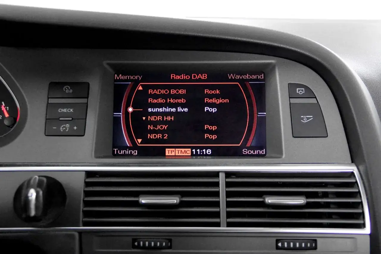 Audi A6-display visar radiostationer, kanske ett problem med ljudet? Solsken live och popmusik spelas.