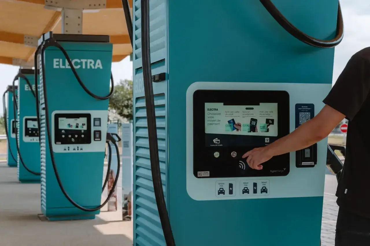 En person använder ett laddkort elbil vid en Electra-laddstation.