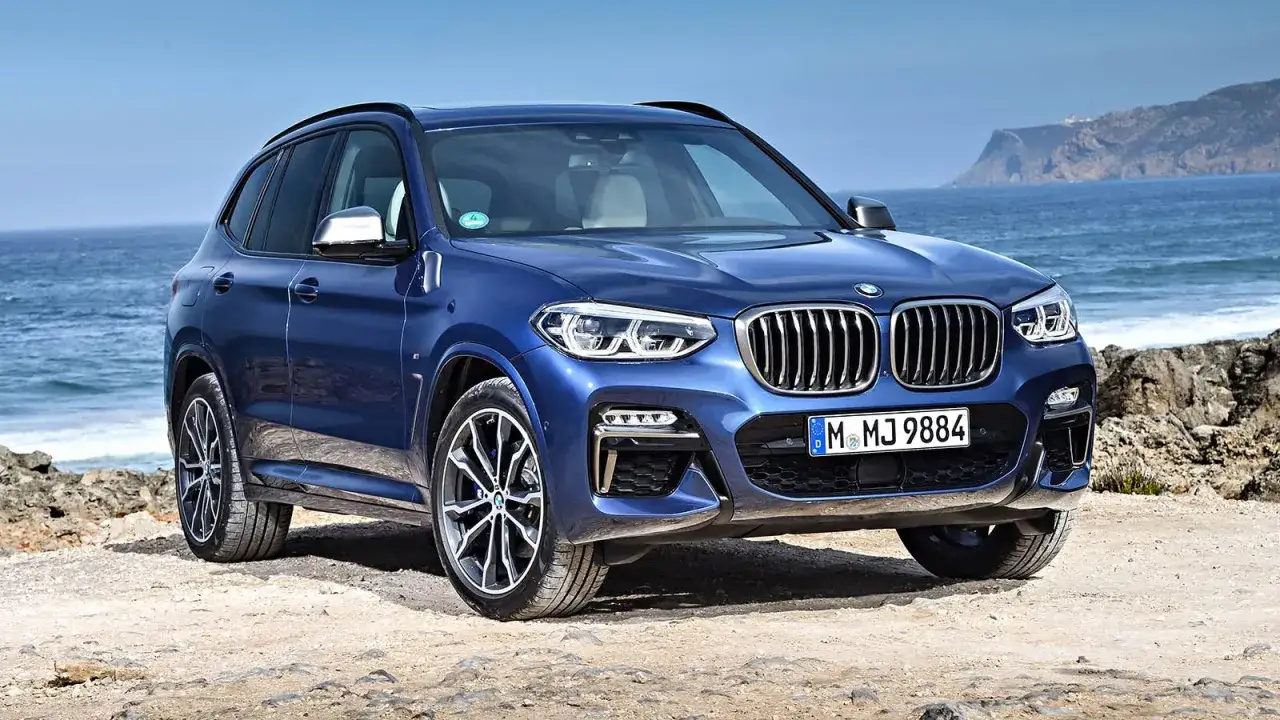 Blå BMW X3 vid havet. Kanske ett problem med att hitta parkering här?