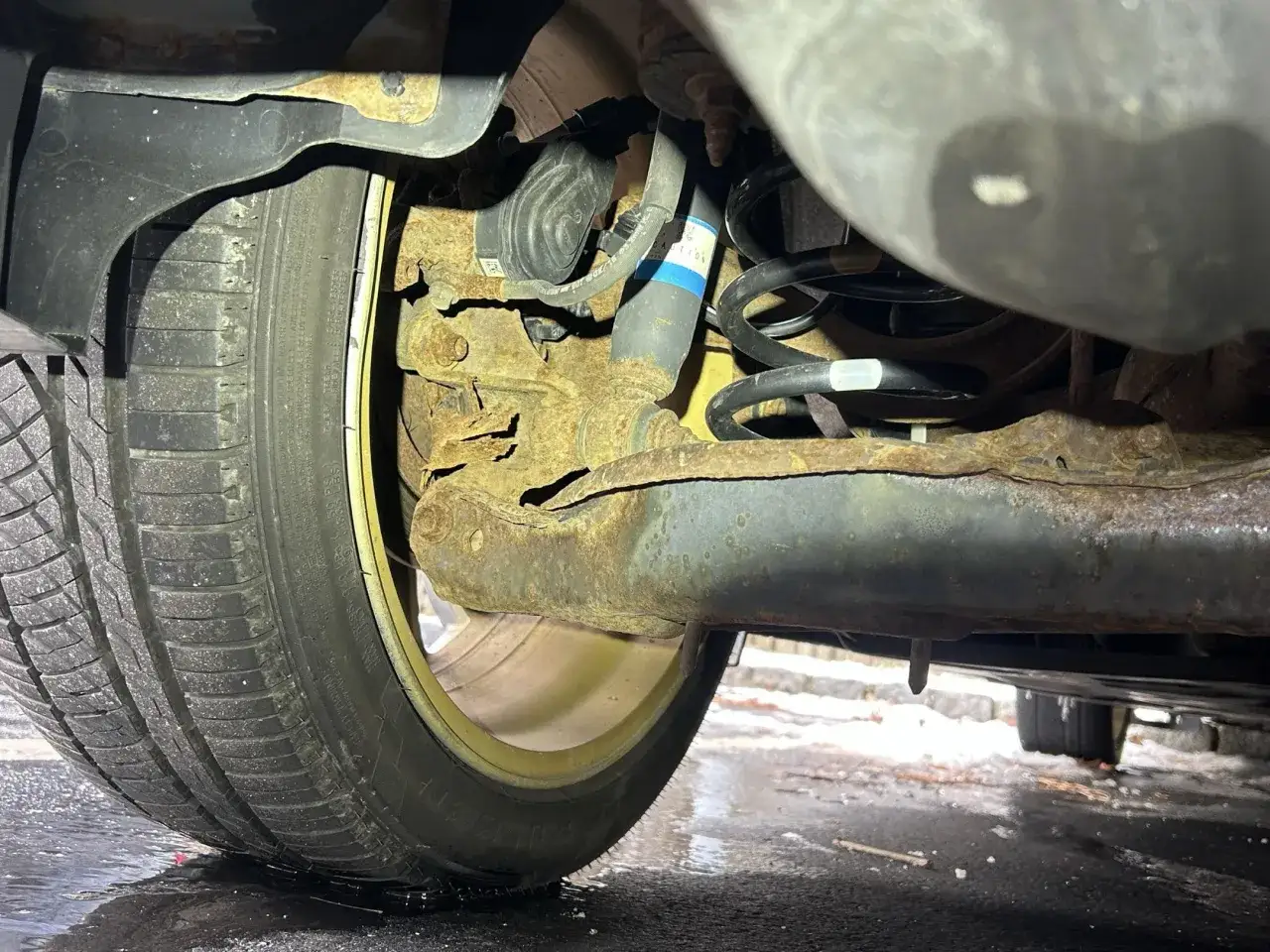 Rostig bakre hjulupphängning på en Mazda 6, ett tydligt problem med rostskador.