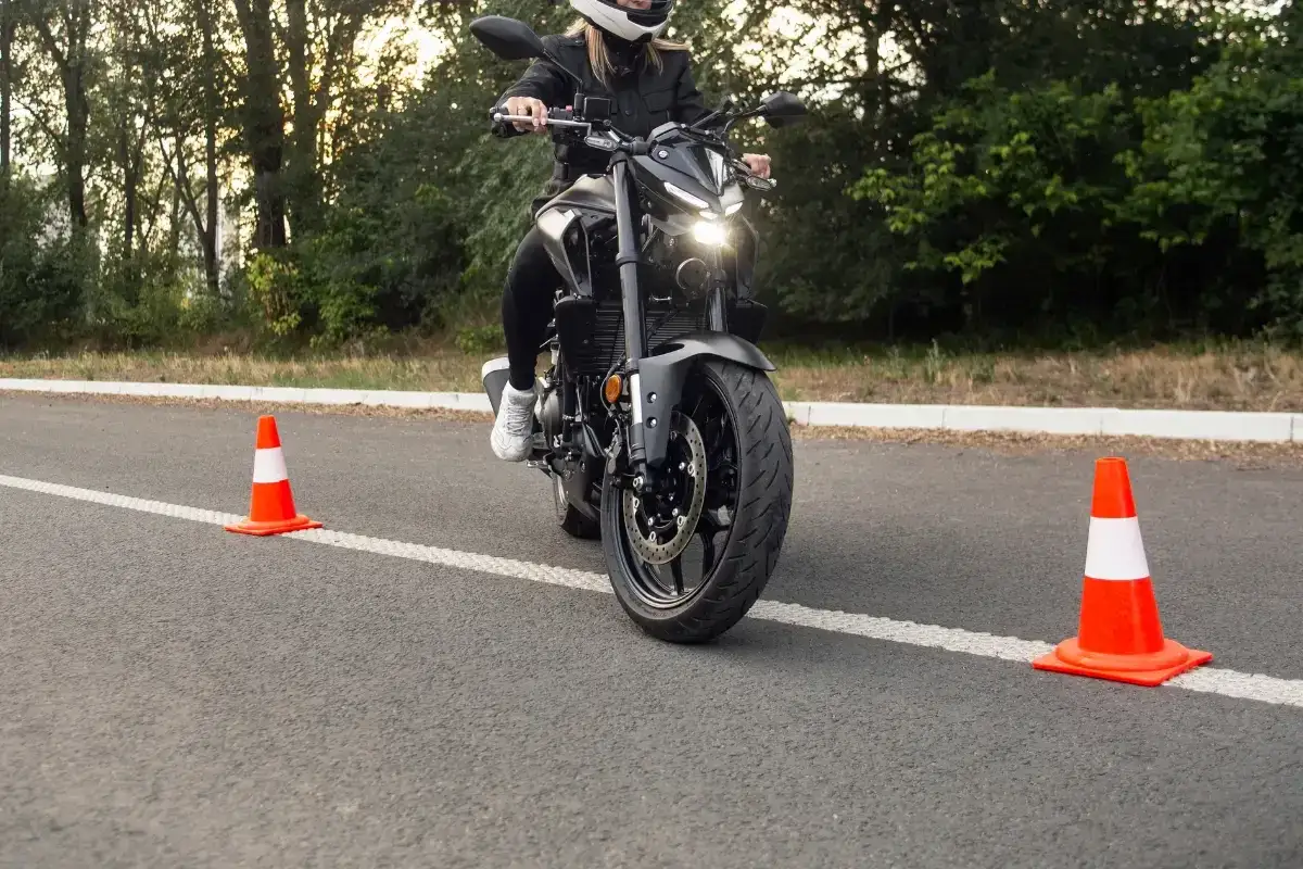 Person p&aring; motorcykel &ouml;var p&aring; en l&aring;gfartsbana mc, med koner utplacerade p&aring; asfalten.