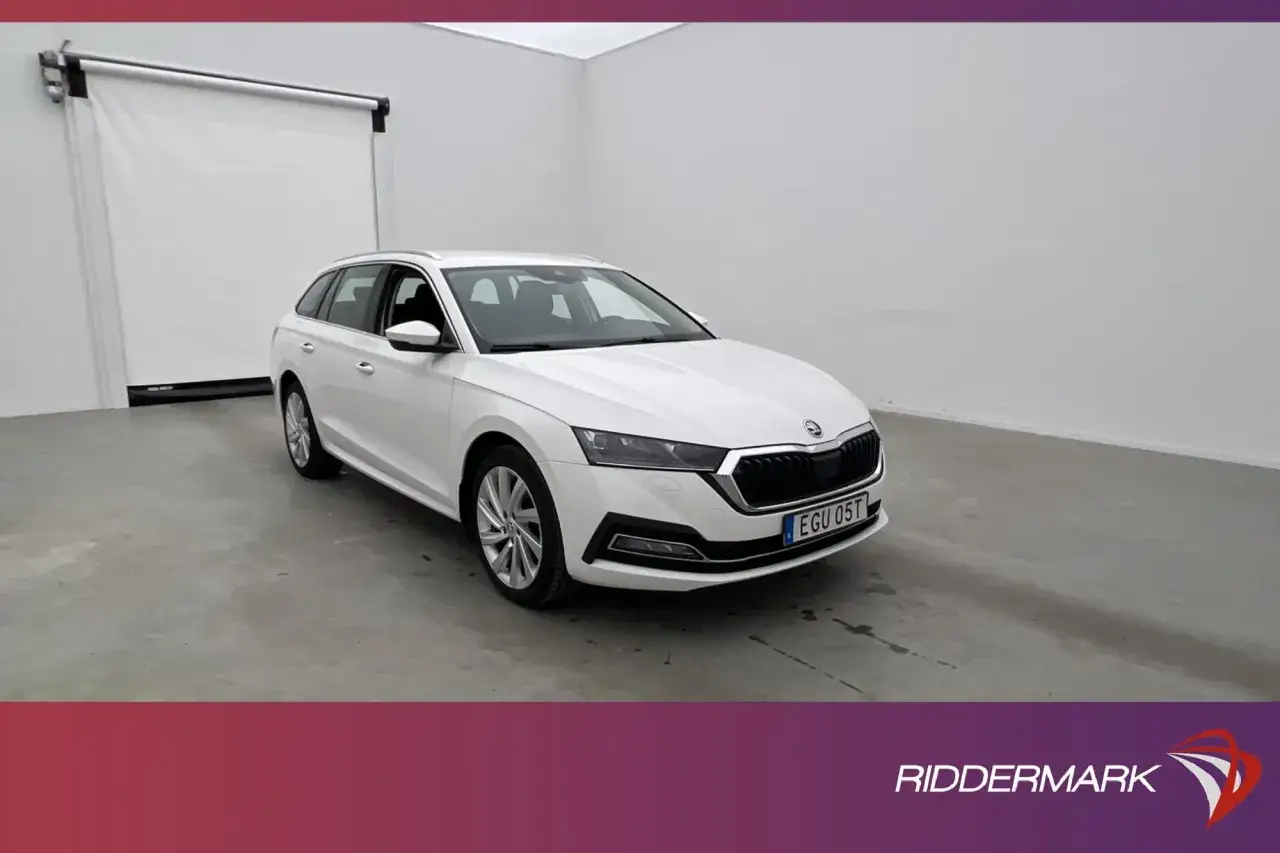 Vit Skoda Octavia laddhybrid i en ljus lokal. Bilen har en modern design med skarpa linjer och en grill som ger ett kraftfullt intryck.