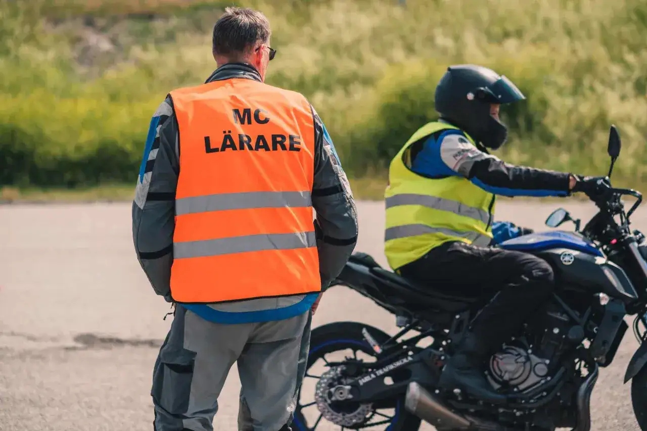 MC-lärare övervakar en elev på en a1 motorcykel under körutbildning.