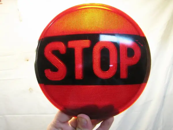 Rött stoppskylt med texten "STOP" i svarta bokstäver. En klassisk olja symbol för att stanna.
