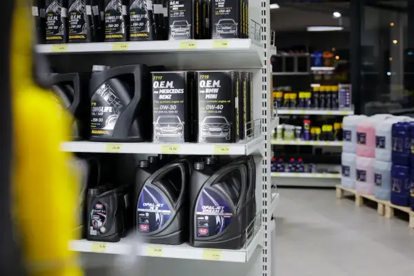 Hyllor fyllda med motoroljor, inklusive helsyntetisk olja för olika bilmärken.