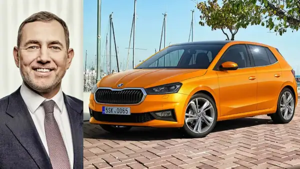 En leende man bredvid en orange Skoda Kamiq. Kanske är det en ny modell, eller så finns det ett Skoda Kamiq problem som diskuteras.